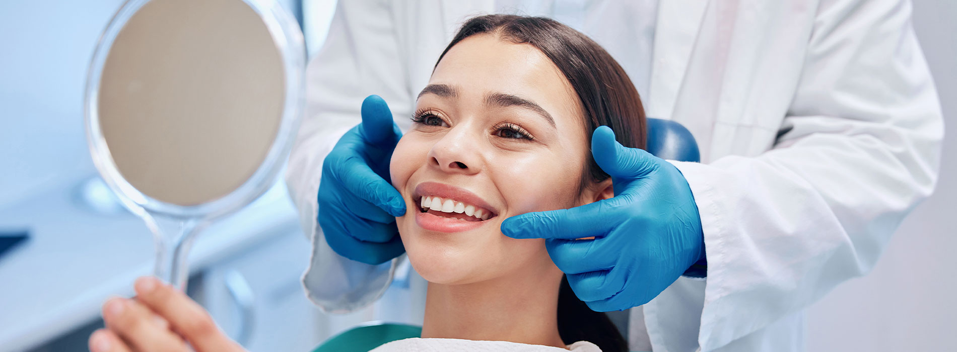 The image depicts a person receiving a beauty treatment, likely at a salon or spa, with a professional attendant in the background using a handheld mirror to assist.