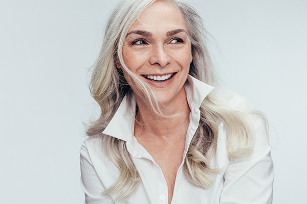 A woman with short hair smiles at the camera.