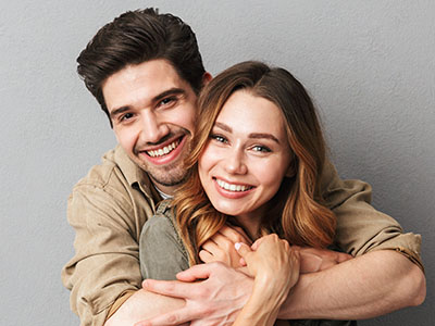 A man and woman are embracing each other in a warm, affectionate pose.