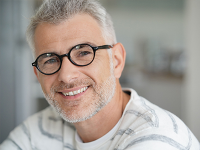 A middle-aged man with a beard and glasses, smiling at the camera.